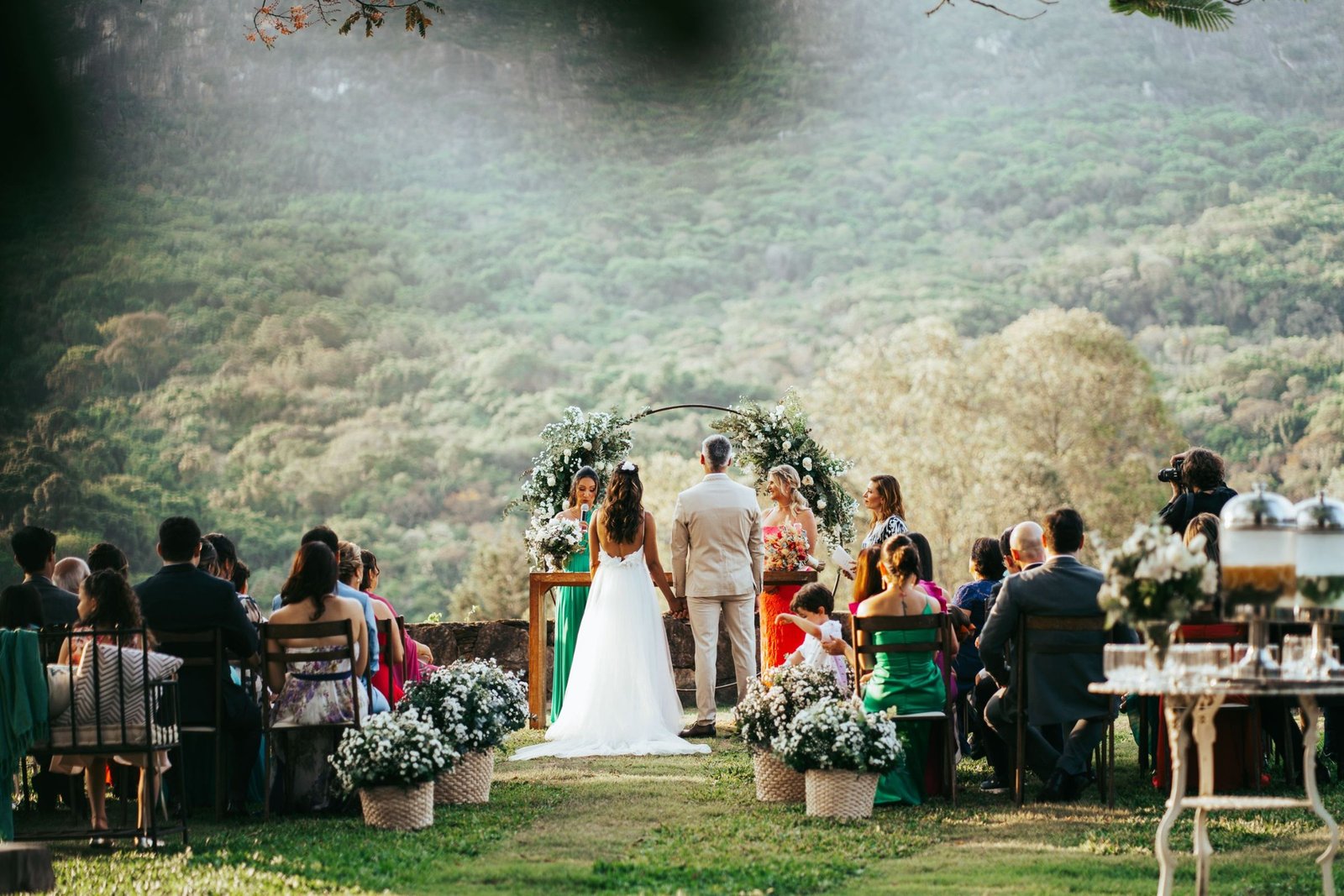 Outdoor wedding ceremony beneath a forested mountain